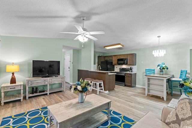 8546 Hopkins Cir Unit G, Surfside Beach, SC 29575 - living room featuring light wood-type flooring, a ceiling fan, baseboards, a chandelier, and vaulted ceiling