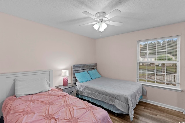 8546 Hopkins Cir Unit G, Surfside Beach, SC 29575 - bedroom featuring wood finished floors, baseboards, a textured ceiling, and ceiling fan