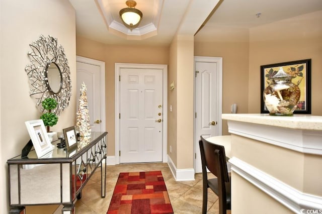 entrance foyer featuring light tile patterned floors and a raised ceiling