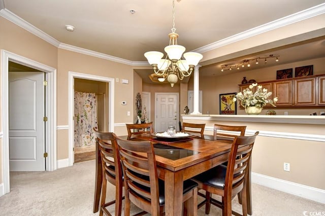 dining area with a chandelier, light carpet, ornate columns, and crown molding