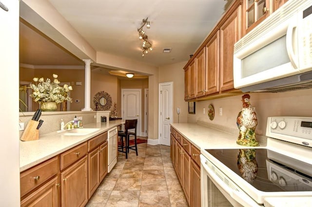 kitchen featuring ornate columns, ornamental molding, sink, and white appliances