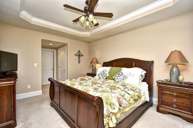 carpeted bedroom with ceiling fan, crown molding, and a tray ceiling