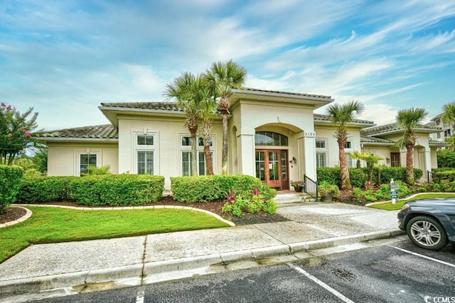 mediterranean / spanish-style house featuring french doors and a front yard