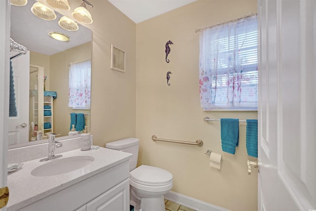 bathroom with toilet, vanity, and tile patterned floors