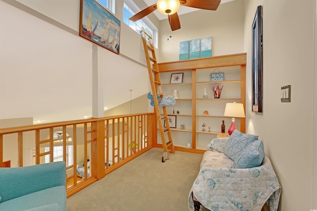 sitting room with high vaulted ceiling, light carpet, and ceiling fan