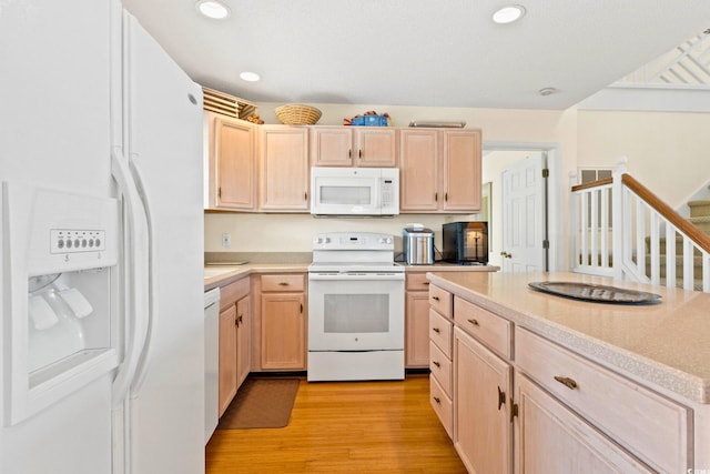 kitchen with white appliances, light brown cabinetry, and light wood-type flooring
