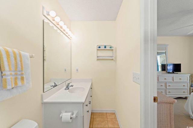 bathroom with toilet, vanity, tile patterned flooring, and ceiling fan