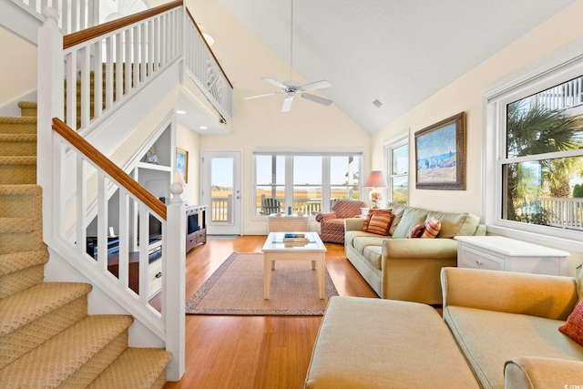 living room with high vaulted ceiling, ceiling fan, and light hardwood / wood-style floors