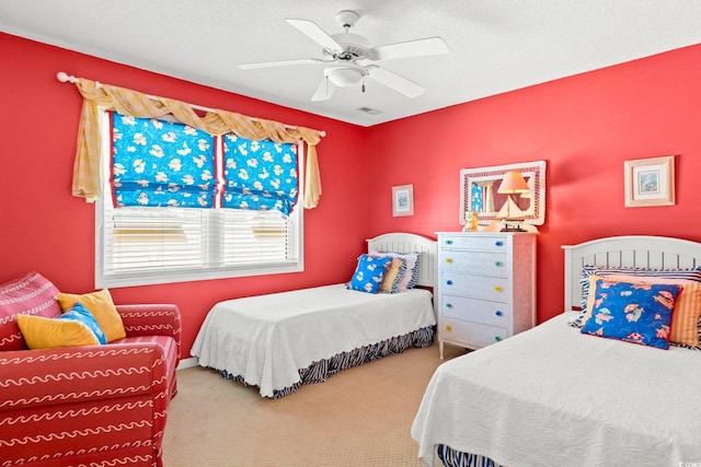 bedroom with ceiling fan, a textured ceiling, and carpet