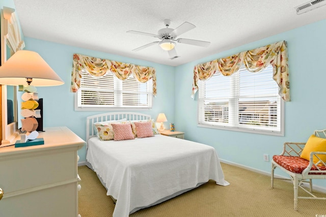 bedroom featuring a textured ceiling, carpet flooring, and ceiling fan