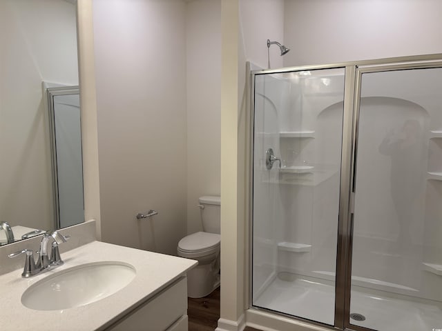 bathroom with vanity, wood-type flooring, an enclosed shower, and toilet