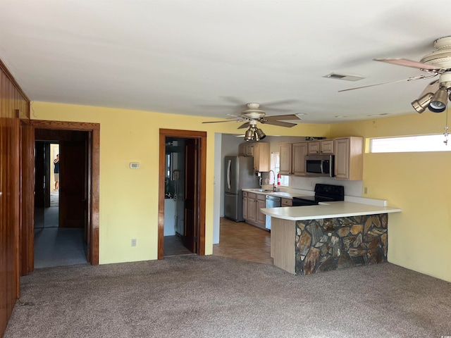 kitchen featuring stainless steel appliances, sink, kitchen peninsula, ceiling fan, and light colored carpet