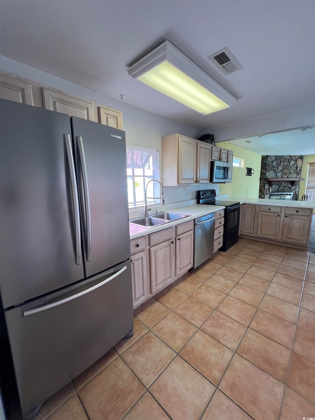 kitchen with light brown cabinets, sink, and appliances with stainless steel finishes