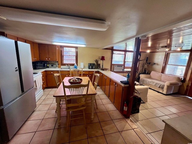 kitchen featuring plenty of natural light, white range with electric cooktop, sink, and stainless steel refrigerator