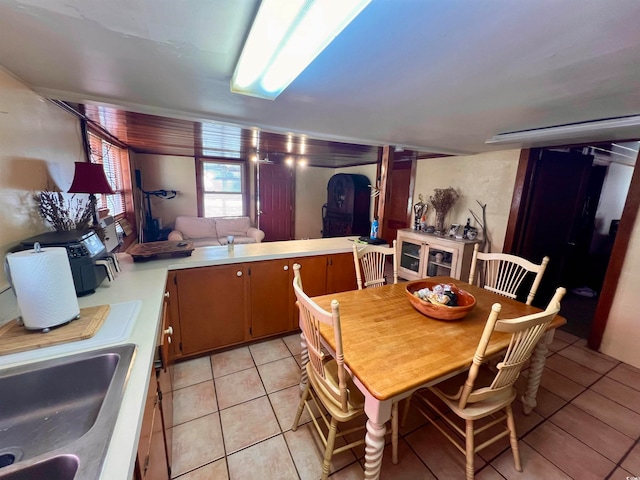 kitchen with kitchen peninsula, light tile patterned floors, and sink