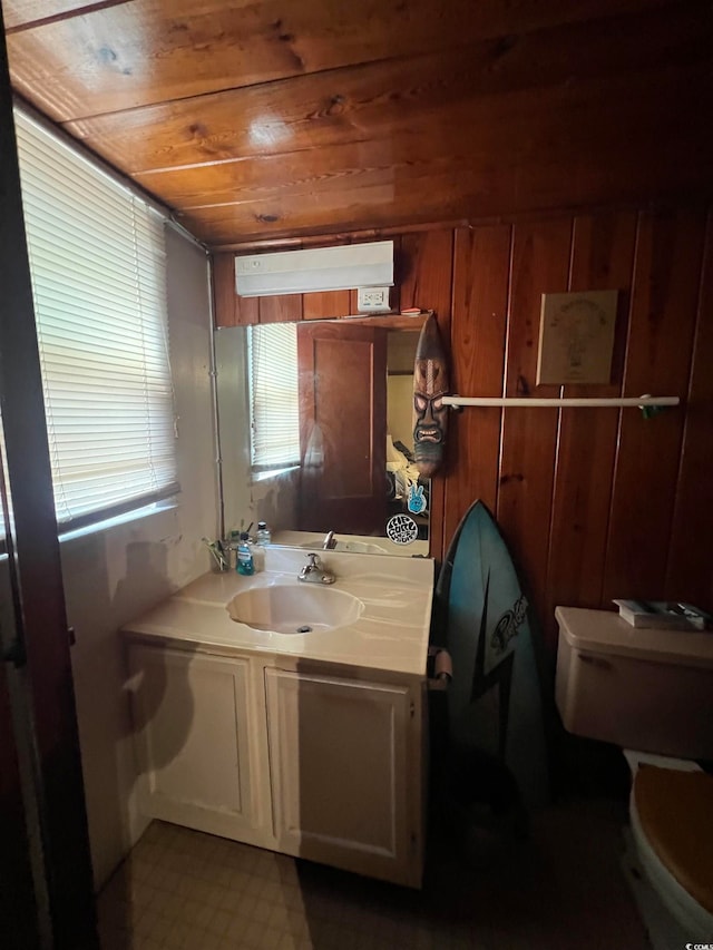 bathroom featuring vanity, wood ceiling, wooden walls, and toilet