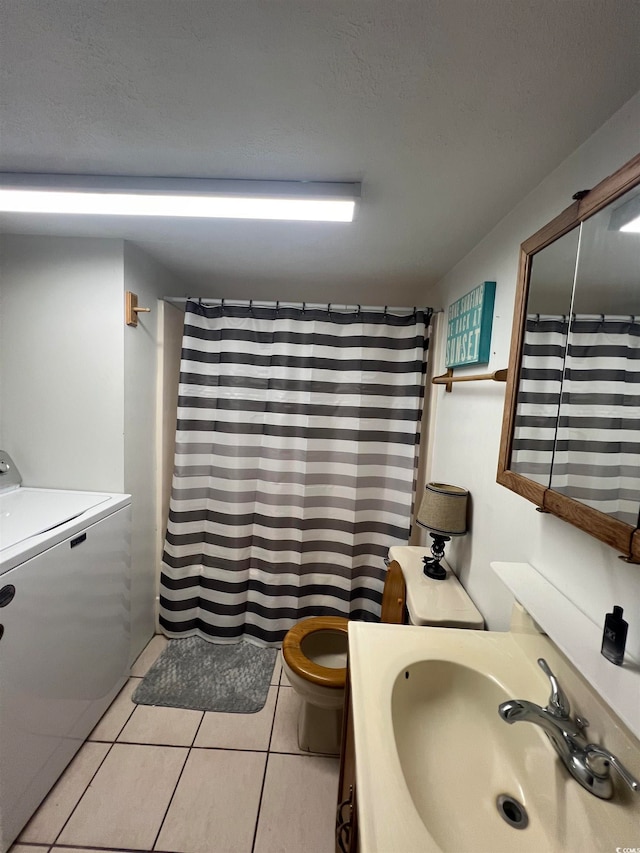 bathroom featuring tile patterned flooring, sink, curtained shower, washer / dryer, and toilet