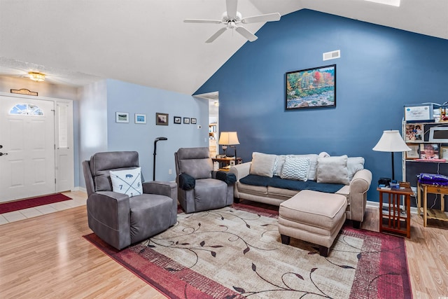 living room featuring wood finished floors, a ceiling fan, high vaulted ceiling, and baseboards