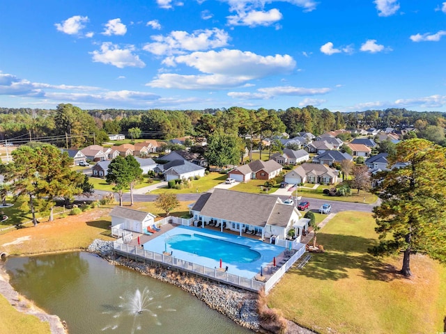 aerial view of residential area featuring a pool area and a large body of water