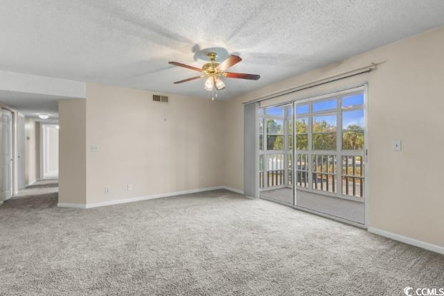 carpeted spare room featuring ceiling fan and a textured ceiling