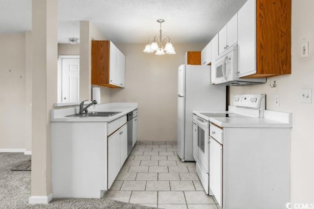 kitchen featuring white appliances, white cabinetry, sink, and decorative light fixtures