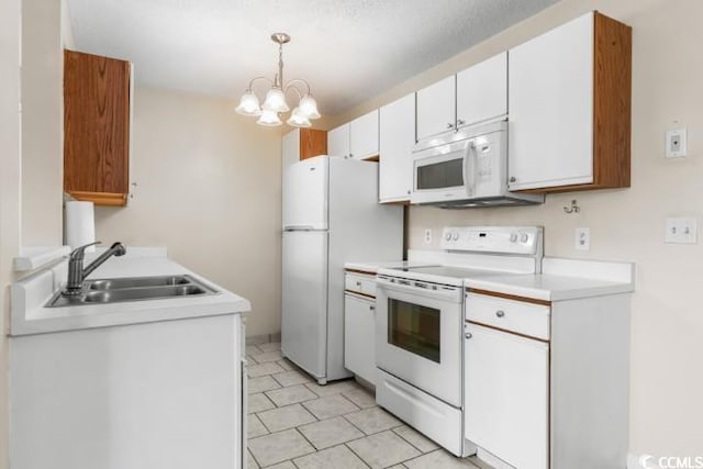 kitchen featuring sink, hanging light fixtures, white appliances, a chandelier, and white cabinets