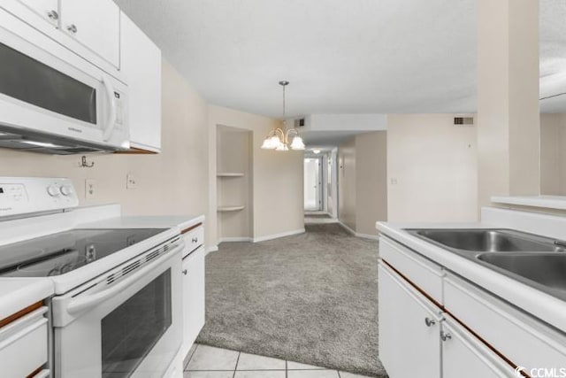 kitchen featuring white cabinetry, a notable chandelier, light carpet, hanging light fixtures, and white appliances