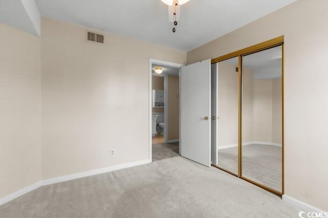 unfurnished bedroom with a closet and light colored carpet