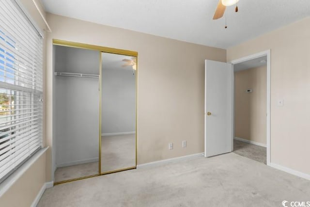 unfurnished bedroom featuring light carpet, ceiling fan, and a closet