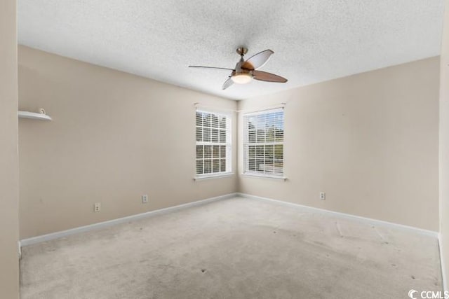 carpeted spare room featuring a textured ceiling and ceiling fan