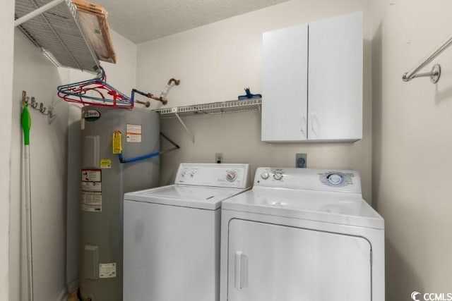 laundry area with washer and clothes dryer, cabinets, a textured ceiling, and electric water heater