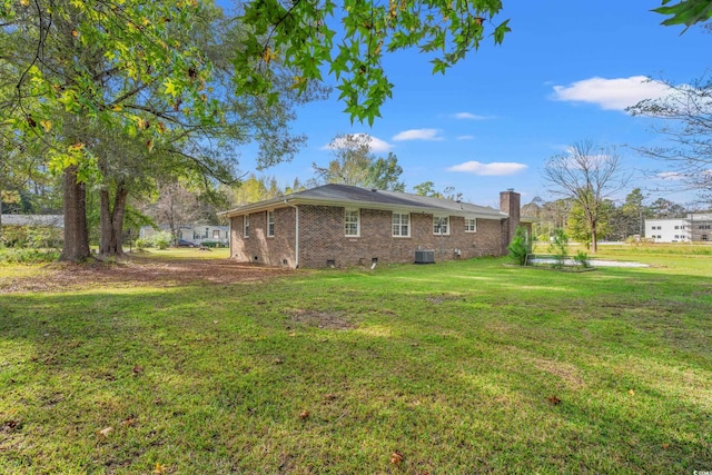 view of side of property with central AC and a yard