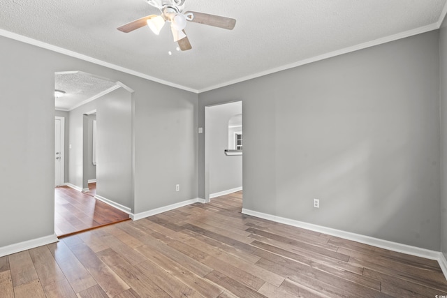 unfurnished room with ceiling fan, ornamental molding, a textured ceiling, and light wood-type flooring