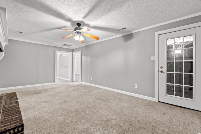 carpeted spare room featuring a textured ceiling, ceiling fan, and crown molding