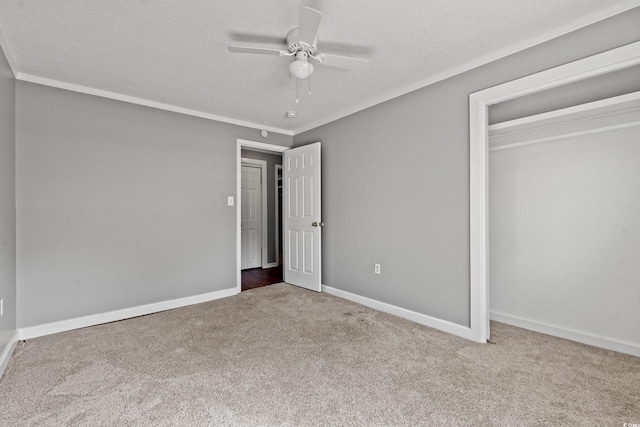 unfurnished bedroom featuring carpet flooring, ceiling fan, a closet, and a textured ceiling