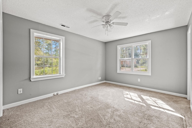 carpeted empty room featuring ceiling fan and a textured ceiling