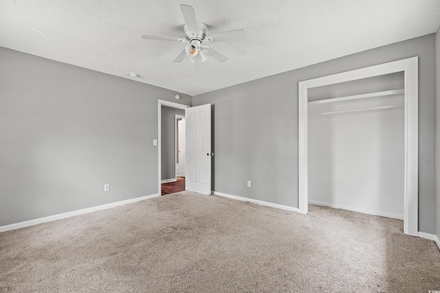 unfurnished bedroom with carpet, ceiling fan, a textured ceiling, and a closet