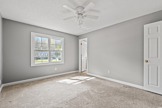 spare room featuring ceiling fan, carpet, and a textured ceiling