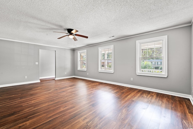 empty room featuring a textured ceiling, crown molding, and dark hardwood / wood-style floors