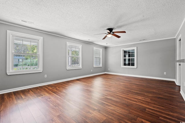 empty room featuring a textured ceiling, a healthy amount of sunlight, and dark wood-type flooring