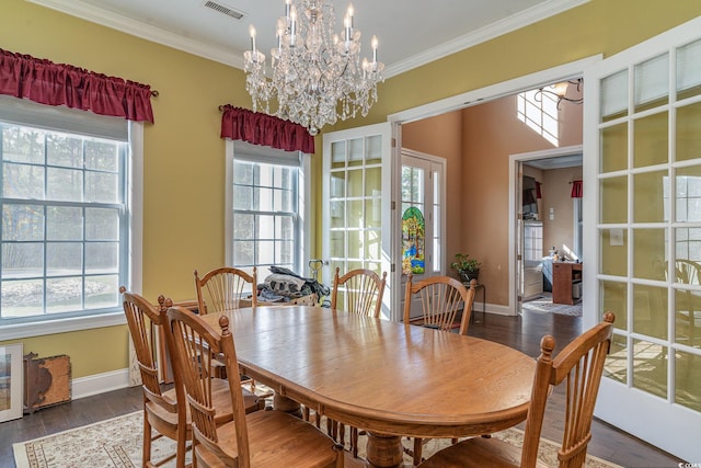 dining area with dark hardwood / wood-style floors, plenty of natural light, and crown molding