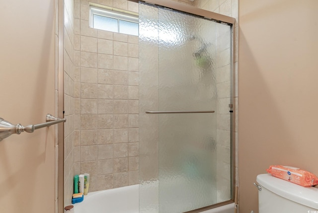 bathroom with enclosed tub / shower combo and toilet