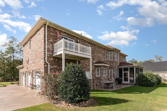 back of house featuring a sunroom, a garage, a yard, and a balcony