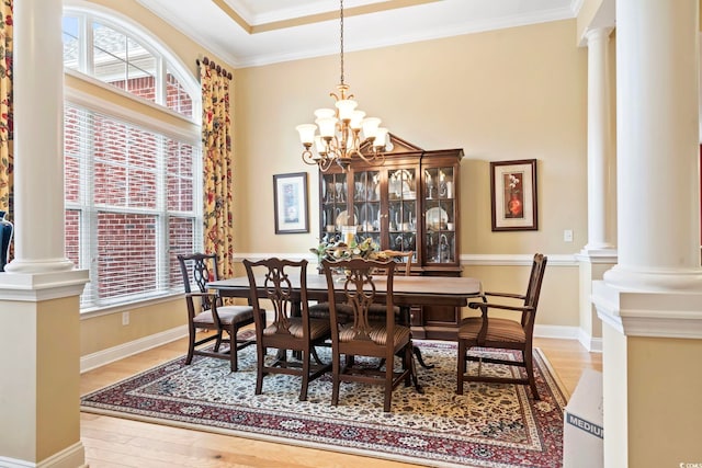 dining space featuring hardwood / wood-style flooring, ornamental molding, and a notable chandelier