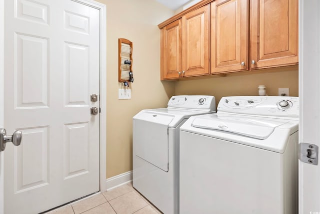 clothes washing area with cabinets, light tile patterned flooring, and separate washer and dryer