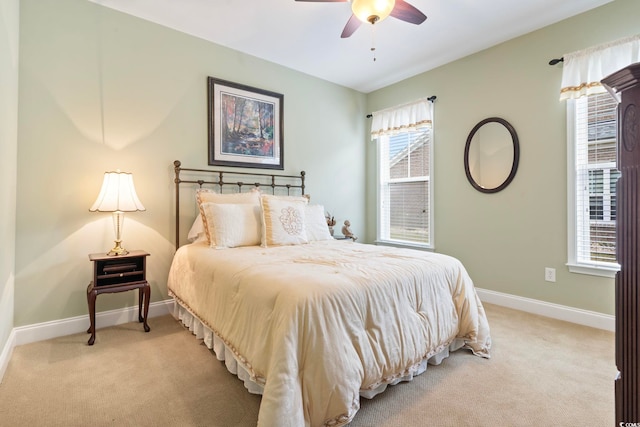 bedroom featuring light carpet, multiple windows, and ceiling fan