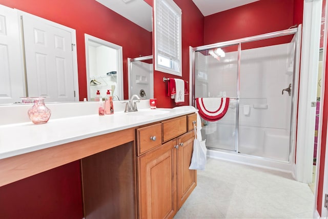 bathroom featuring vanity and a shower with door