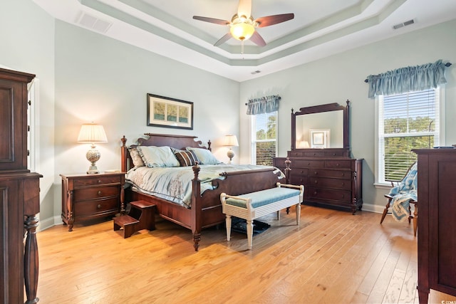 bedroom featuring light wood-type flooring, multiple windows, and ceiling fan