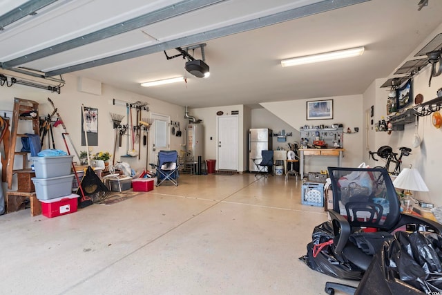 garage featuring a garage door opener, a workshop area, stainless steel refrigerator, and gas water heater