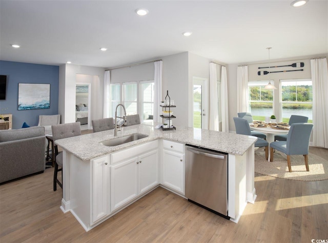 kitchen with sink, white cabinetry, hanging light fixtures, a center island with sink, and stainless steel dishwasher